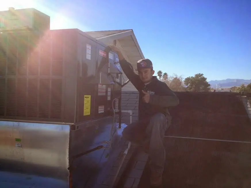 HVAC technician performing Air Duct Repair on a rooftop unit in Tupelo